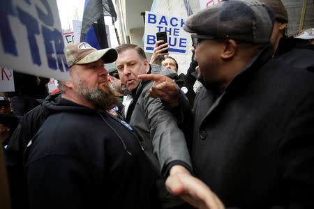 Fraternal Order of Police supporters protesting the handling of the Jussie Smollett case by the State's Attorney Kim Foxx face off with a counter protester (R) in Chicago, Illinois, U.S., April 1, 2019. REUTERS/Joshua Lott