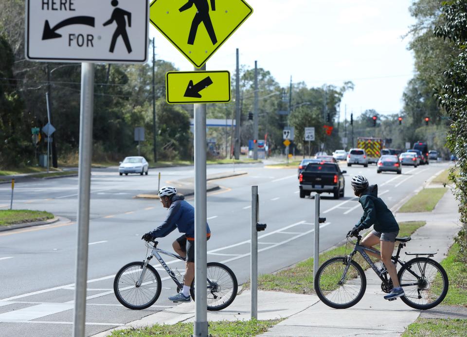 Bicyclists cross Williston Road at the dangerous Hawthorne Trail crossing in Gainesville on Jan. 16. Several accidents have occurred at this crossing, including a woman who was seriously injured while jogging last month.