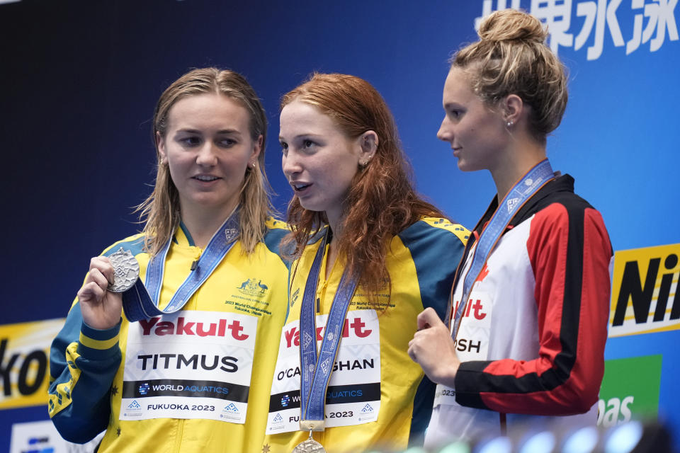 Medalists, from left to right, Ariarne Titmus of Australia, silver, her compatriot Mollie O'Callaghan, gold, and Summer Mcintosh of Canada, bronze, celebrate on the podium during the medal ceremony for the women's 200m freestyle swimming final at the at the World Swimming Championships in Fukuoka, Japan, Wednesday, July 26, 2023. (AP Photo/Eugene Hoshiko)