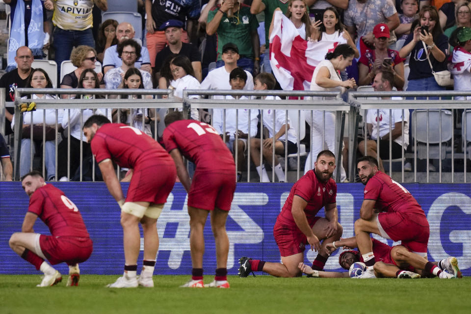 Georgia's Akaki Tabutsadze, second from right, celebrates with teammates after scoring a try during the Rugby World Cup Pool C match between Fiji and Georgia at the Stade de Bordeaux in Bordeaux, France, Saturday, Sept. 30, 2023. (AP Photo/Thibault Camus)