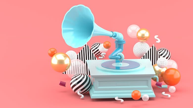 A blue gramophone with colorful balls on a peach background
