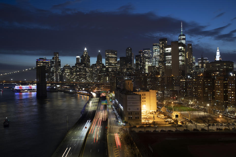 Cars head along FDR Drive next to the Manhattan skyline, Thursday, March 26, 2020, during the coronavirus outbreak in New York. Because of Gov. Andrew Cuomo's "stay-at-home" orders for all but essential workers, the streets and highways are quieter than normal. (AP Photo/Mark Lennihan)