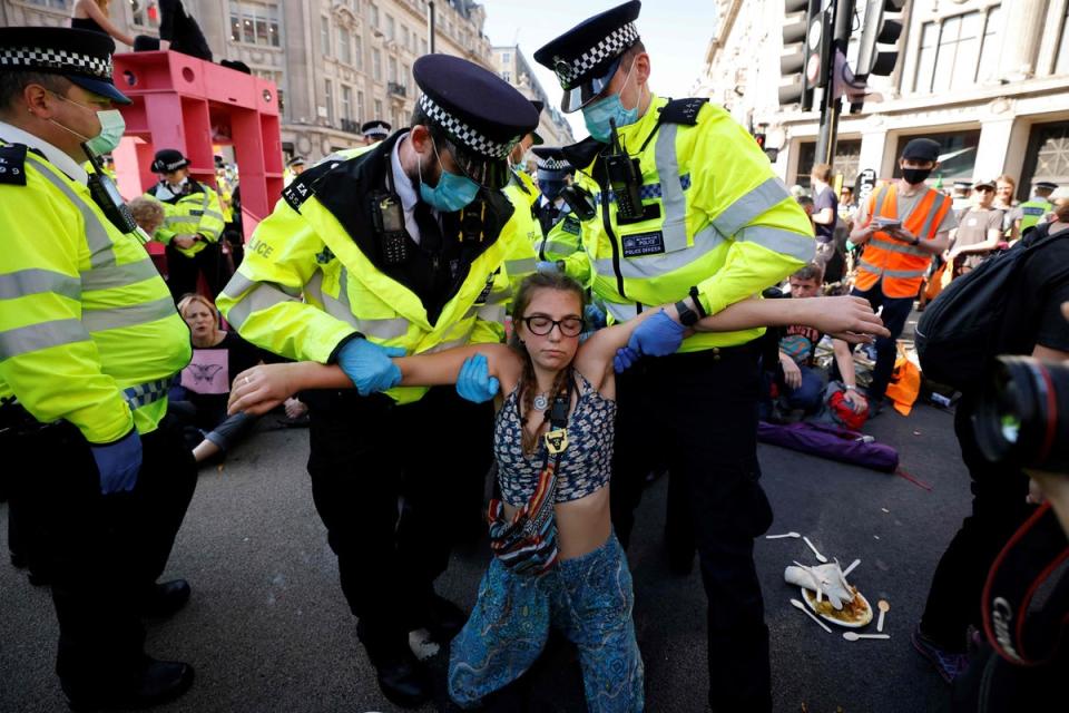 Police officers carry an Extinction Rebellion activist during a series of actions in central London. in August 2021 . The group said it would shift tactics in early 2023 (AFP via Getty Images)