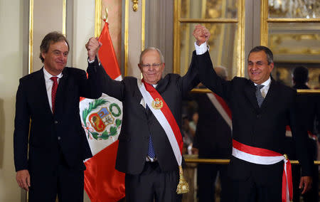 Peru's President Pedro Pablo Kuczynski holds hands with new Interior Minister Vicente Romero (R) and former Interior Minister Carlos Basombrio during the minister swearing-in ceremony at the government palace in Lima, Peru December 27, 2017. REUTERS/Guadalupe Pardo