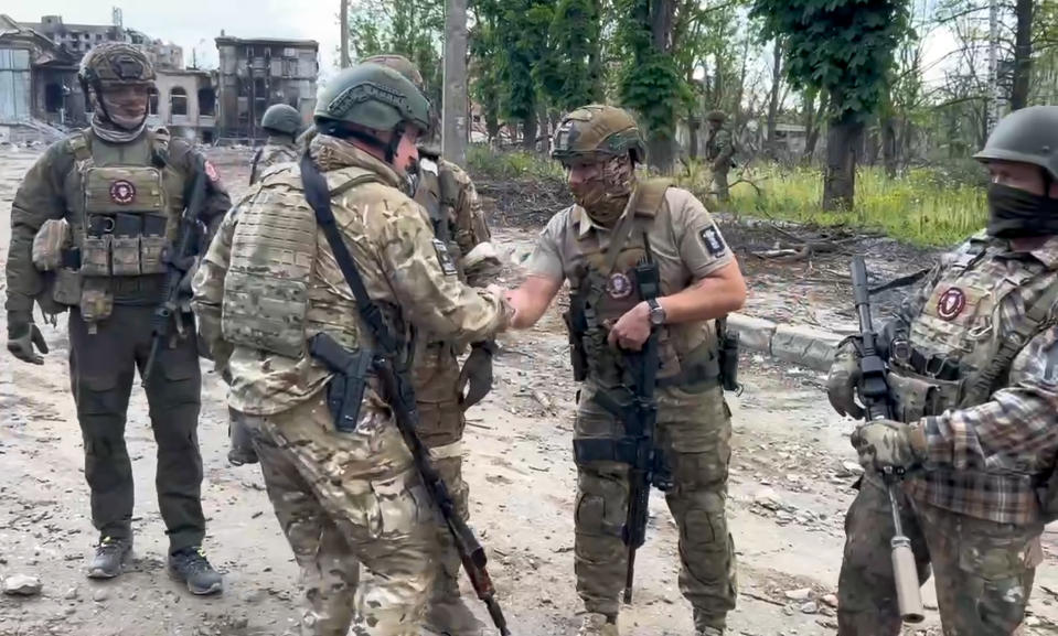 In this grab taken from video released by Prigozhin Press Service on Saturday, May 20, 2023, Yevgeny Prigozhin, the owner of the Wagner Group military company shakes hands with his soldiers, in Bakhmut, Ukraine. Prigozhin claims his forces have taken control of the city of Bakhmut after the longest and most grinding battle of the Russia-Ukraine war, but Ukrainian defense officials have denied it. In a video posted on Telegram, Prigozhin said the city came under complete Russian control at about midday Saturday. (Prigozhin Press Service via AP)