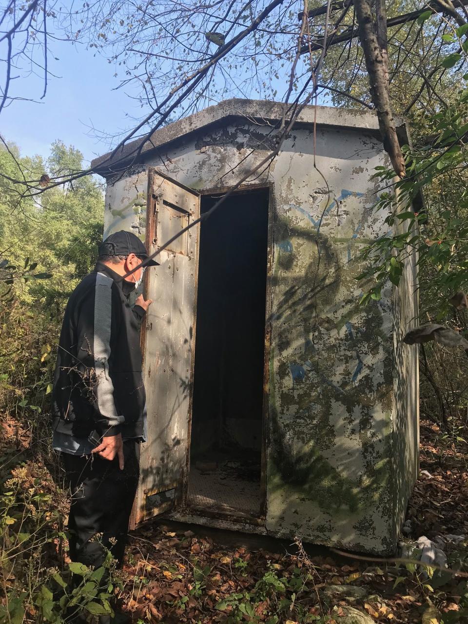 Bob Hernandez opens a door on a small railroad storage shed where people have stayed in the past. He saw two large blankets inside on Thursday. Image via John Ferak/Joliet Patch