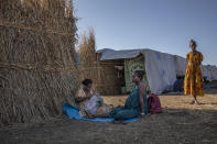 Ethiopian Amhara refugee 8-month pregnant Blaines Alfao Eileen, right, sits with Tigray refugee 25-year-old Lemlem Haylo Rada, holding her one-month old baby who was born on a street as she fled, at Um Rakuba refugee camp in Qadarif, eastern Sudan, Monday, Nov. 23, 2020. Tens of thousands of people have fled a conflict in Ethiopia for Sudan, sometimes so quickly they had to leave family behind. There is not enough to feed them in the remote area of southern Sudan that they rushed to. (AP Photo/Nariman El-Mofty)