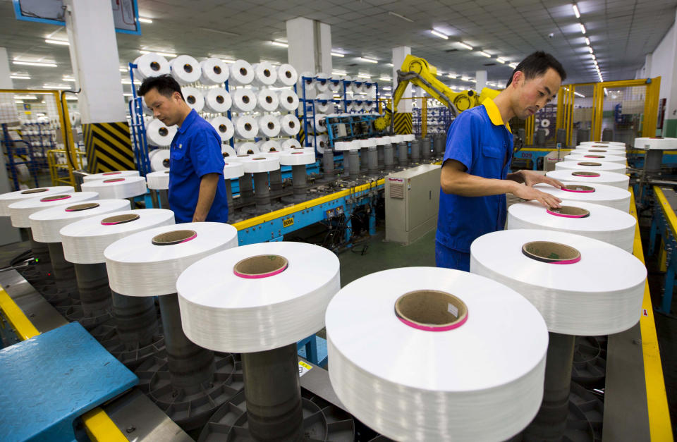 Employees work along a production line of a textile factory in Suzhou, Jiangsu province, China, June 13, 2015. China's factory sector contracted by the most in 15 months in July as shrinking orders depressed output, a preliminary private survey showed on July 24, 2015. Picture taken June 13, 2015. REUTERS/China Daily CHINA OUT. NO COMMERCIAL OR EDITORIAL SALES IN CHINA