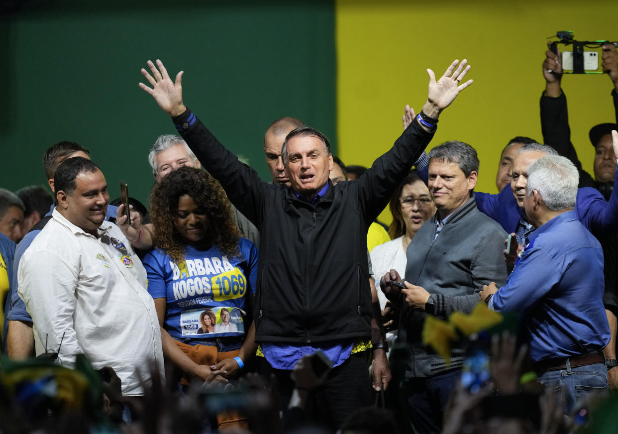 Brazilian President Jair Bolsonaro, who is running for a second term, waves to supporters during a campaign rally in Santos, Brazil, Wednesday, Sept. 28, 2022. Brazil's general elections are scheduled for Oct. 2. A former army captain, Bolsonaro campaigned in 2018 on an anti-corruption platform while defending a show-no-mercy approach to crimefighting, traditional family values and national pride. His 2018 slogan — “Brazil above all, God above everyone” — is back this year. (AP Photo/Andre Penner)