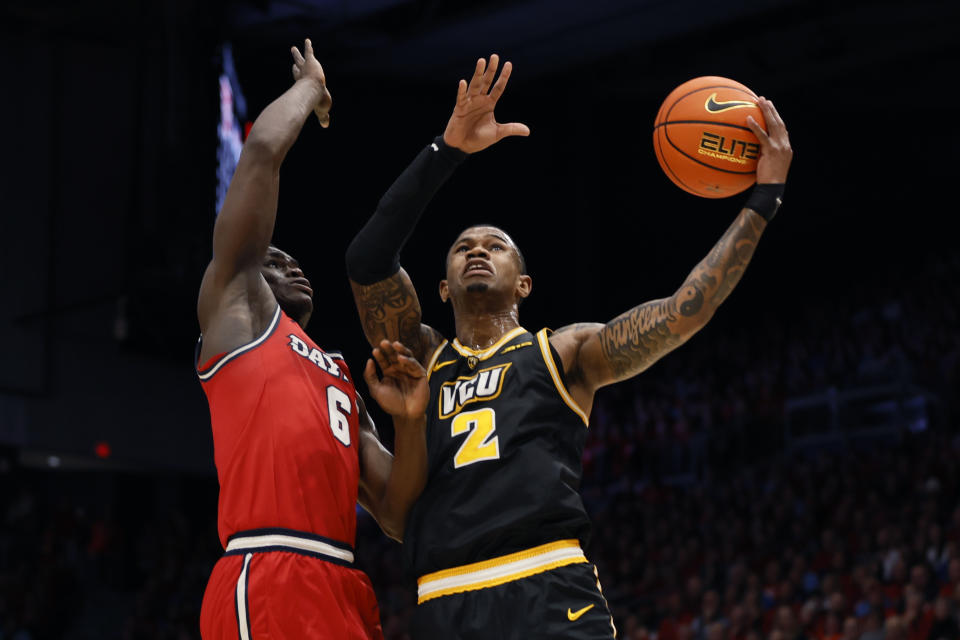 Virginia Commonwealth's Zeb Jackson, right, shoots over Dayton's Enoch Cheeks, left, during the first half of an NCAA college basketball game Friday, March 8, 2024, in Dayton, Ohio. (AP Photo/Jay LaPrete)