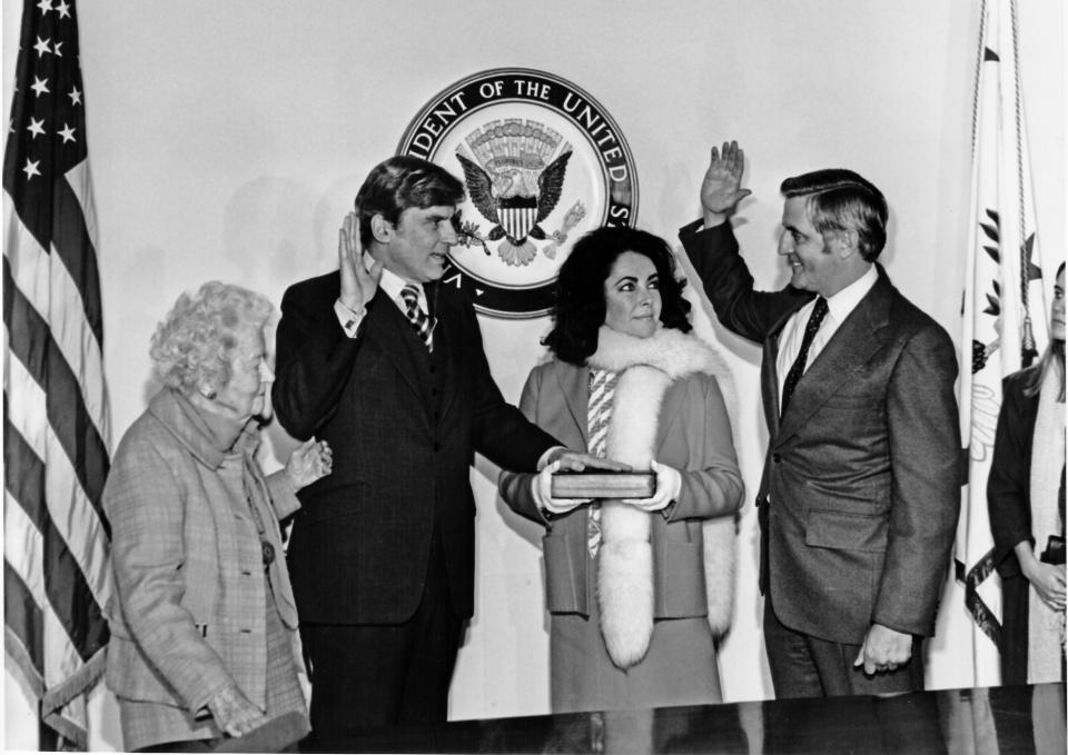 Elizabeth Taylor with John Warner and his mother, Martha Warner, as he is sworn in as senator by Vice President Walter Mondale in 1979.