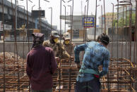 Indian laborers work on the construction of a flyover bridge during lockdown to prevent the spread of new coronavirus in Hyderabad, India, Sunday, April 26, 2020. A month long restrictions in this country of 1.3 billion people have been eased somewhat by allowing neighborhood shops to reopen and manufacturing and farming activities to resume in rural areas to help millions of poor daily wage earners. (AP Photo/Mahesh Kumar A.)