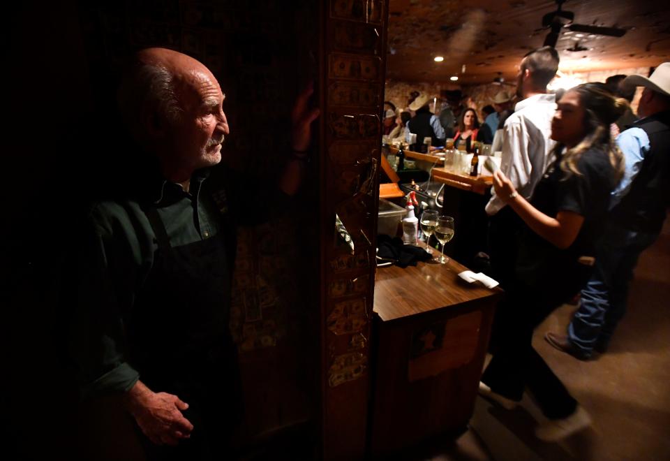 Standing in the hallway leading to the dining room in Albany's Fort Griffin General Merchandise and Beehive Saloon, owner Ali Esfandiary watches his customers enjoy themselves during the restaurant's final weekend.