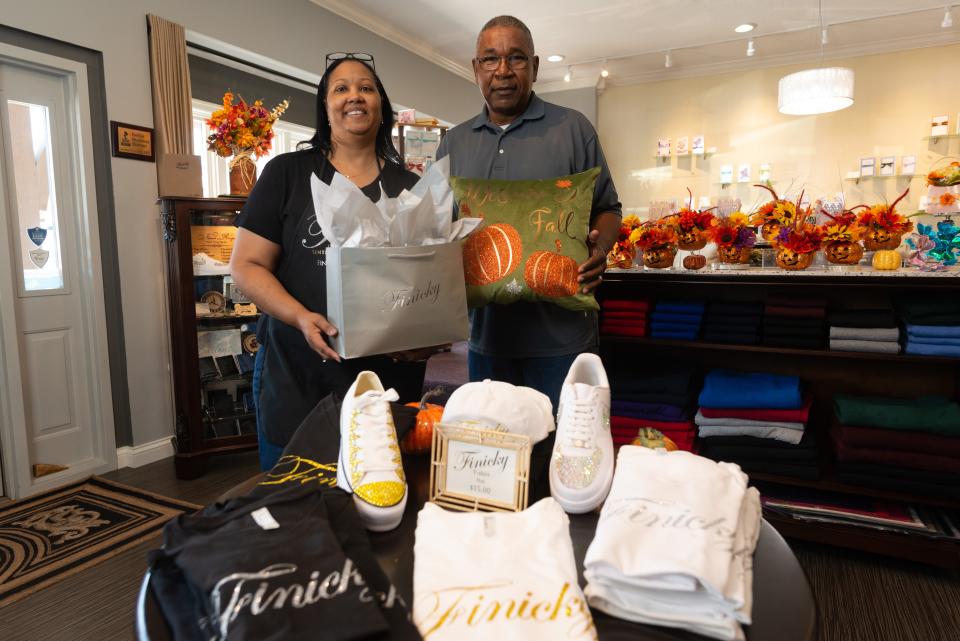 Owners of Finicky, Greg and Janeen Bailey stand with a selection of custom goods and seasonal items in offered at their store at 5618 S.W. 29th St. last Thursday afternoon.