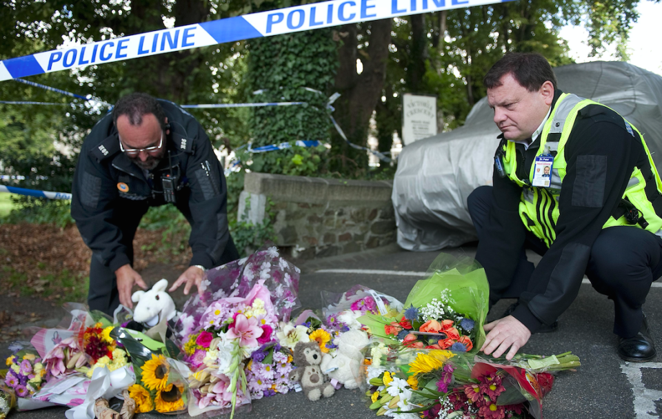 Police officers lay flowers at the scene of the killings in St Helier, Jersey, in 2011 (Picture: Rex)