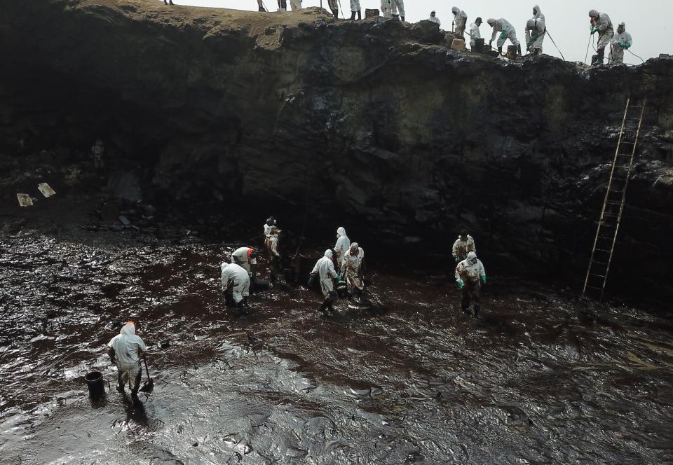 Aerial view of cleaning crews working to remove oil from a beach annexed to the summer resort town of Ancon, northern Lima, on January 22, 2022 after a spill which occurred during the offloading process of the Italian-flagged tanker 