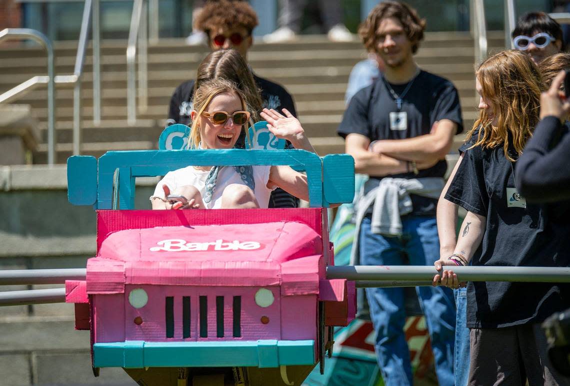 Sophomore Ellie Montgomery, 19, of St. Louis waves to the onlookers in her Malibu Barbie-inspired sculpture pulled along an 80-foot rail for the annual Rail Day tradition at the Kansas City Art Institute.
