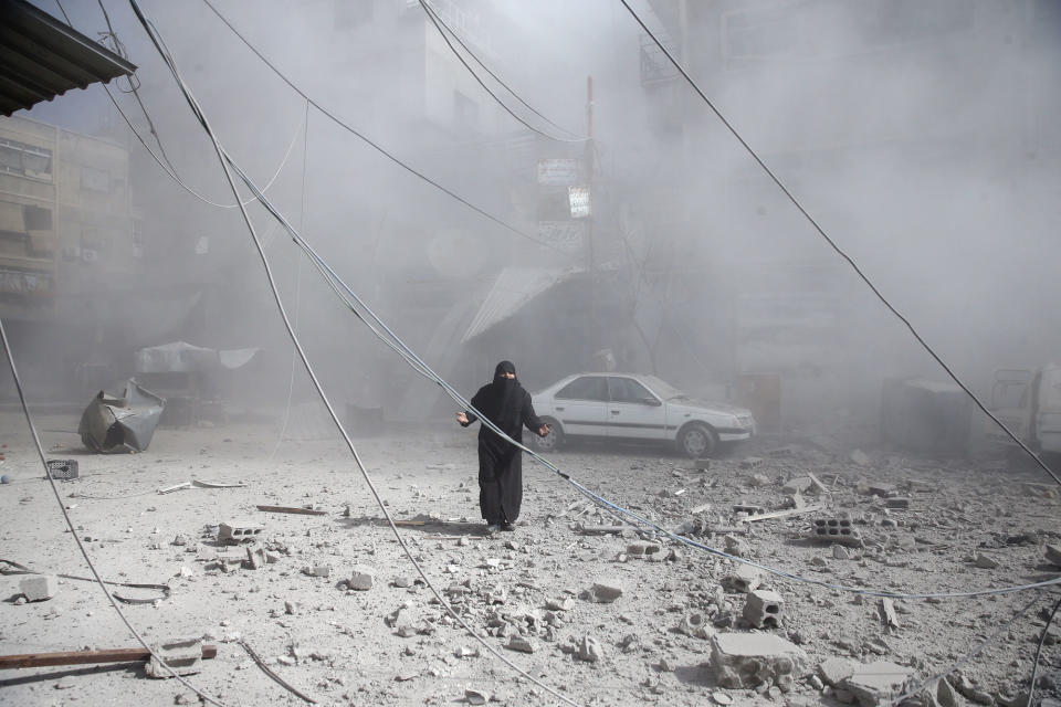 <p>A woman gestures as she walks on rubble of damaged buildings after an airstrike in the besieged town of Douma in eastern Ghouta in Damascus, Syria, Feb. 7, 2018. (Photo: Bassam Khabieh/Reuters) </p>