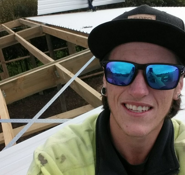 pictured is Jack Lane in sunglasses on a roof while working. 