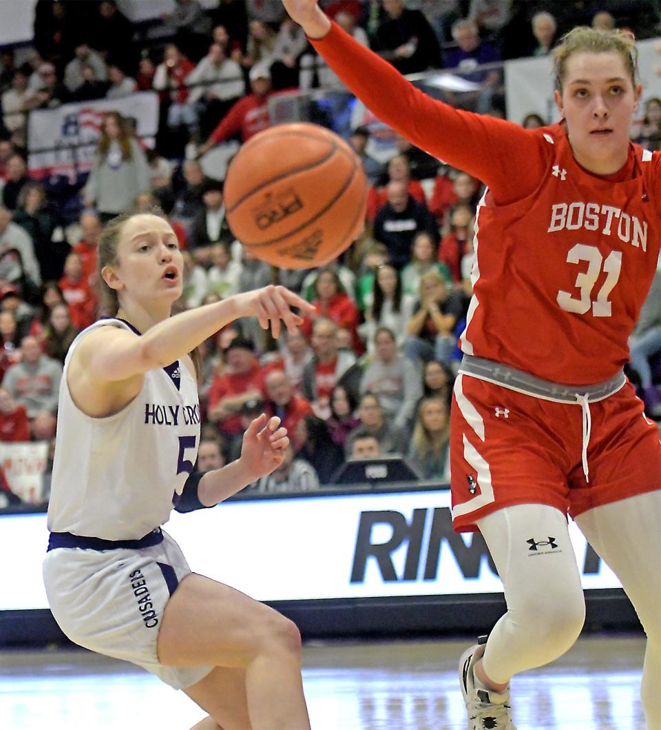 Holy Cross' Kaitlyn Flanagan dishes off a pass past Boston University's Anastasiia Semenova.