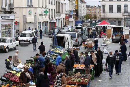 People shop at a market in the neighbourhood of Molenbeek, where Belgian police staged a raid following the attacks in Paris, at Brussels, Belgium November 15, 2015. REUTERS/Yves Herman