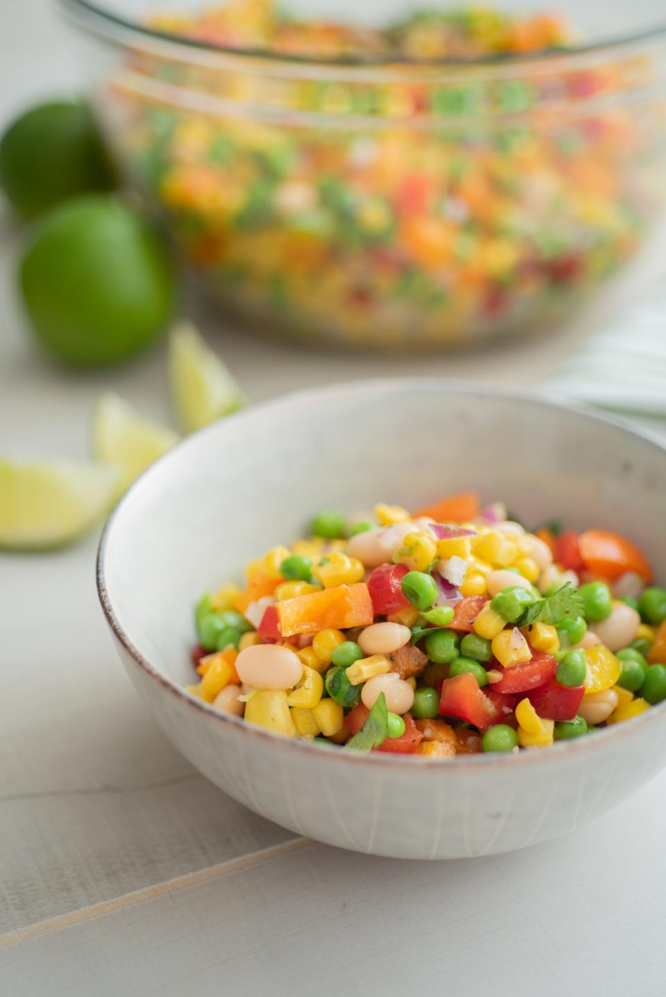 Confetti Salad with Lime-Cilantro Dressing includes peas, corn, beans and red, yellow and orange bell peppers.