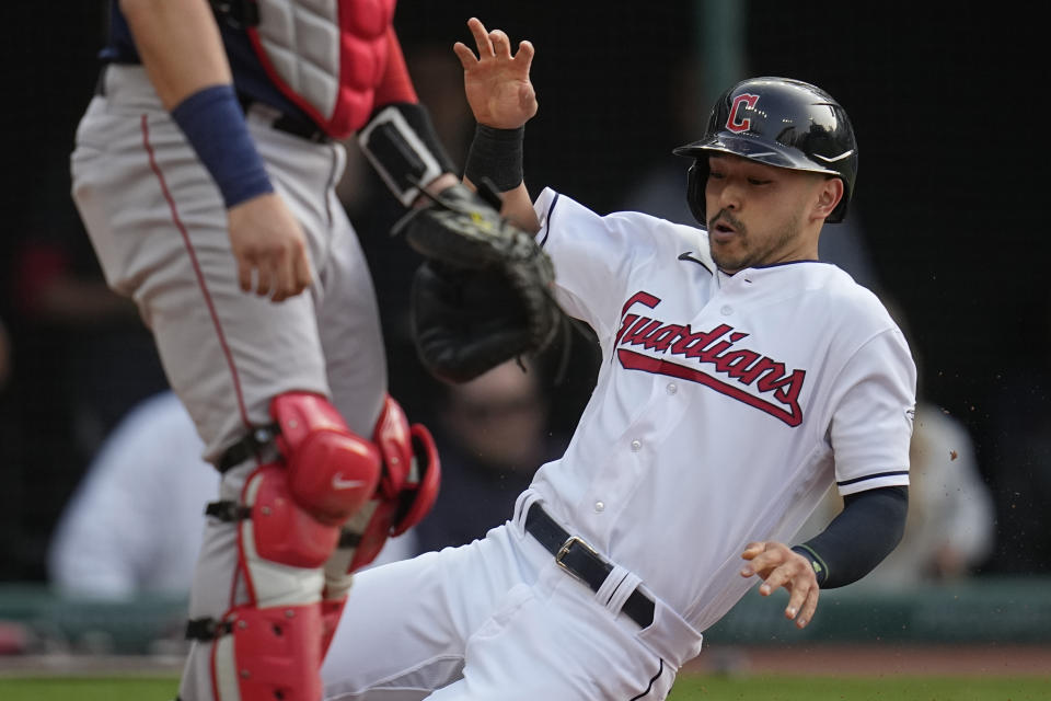 Cleveland Guardians' Steven Kwan slides into home plate next to Boston Red Sox catcher Reese McGuire to score on a hit by Josh Naylor in the first inning of a baseball game Tuesday, June 6, 2023, in Cleveland. (AP Photo/Sue Ogrocki)