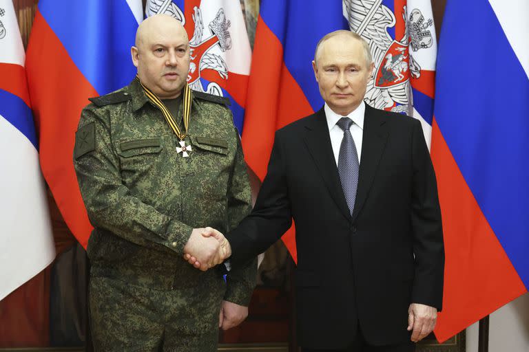 El presidente ruso, Vladimir Putin, a la derecha, se da la mano con el comandante de la operación militar de Rusia en Ucrania, el general Sergei Surovikin, galardonado con la orden de San Jorge de tercera clase, durante una visita a la sede del Distrito Militar del Sur