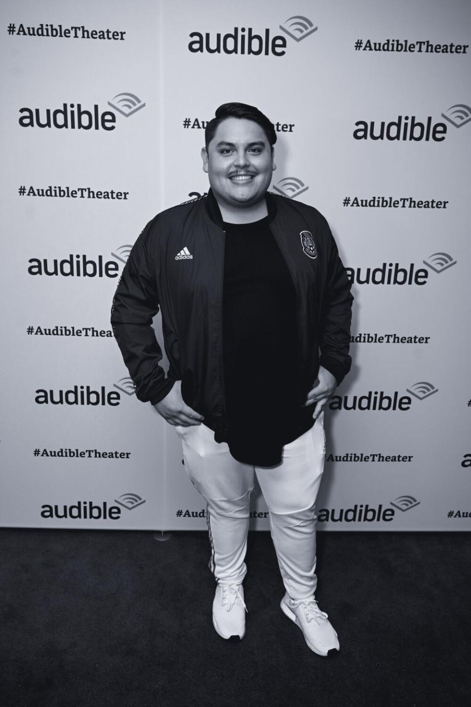 A man in light-colored pants on a red carpet