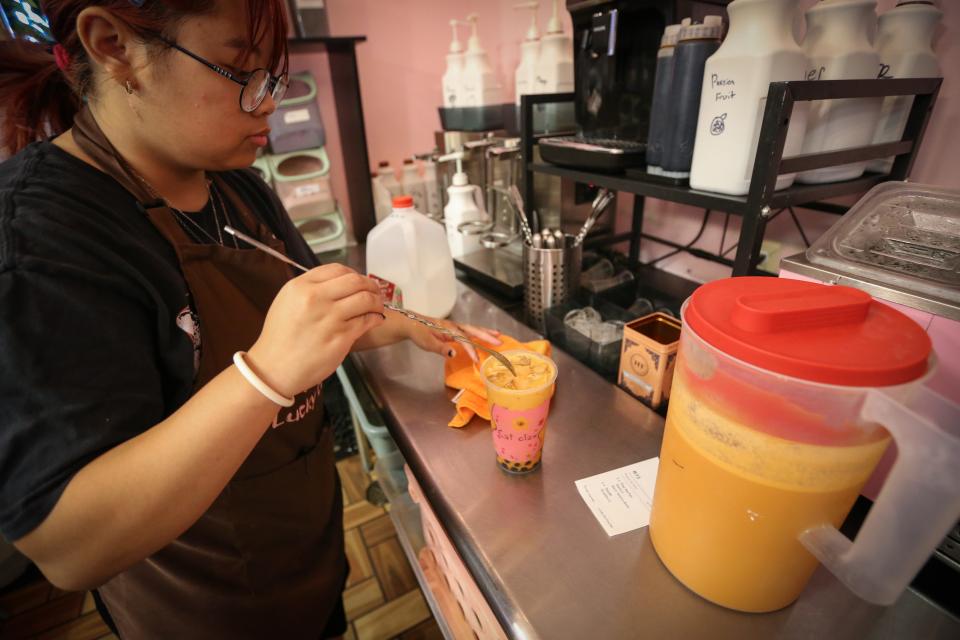 Cindy Nguyen makes a Thai Tea Fan at Lucky Cat Boba Tea and Tayaki on Wednesday, Aug. 16, 2023.