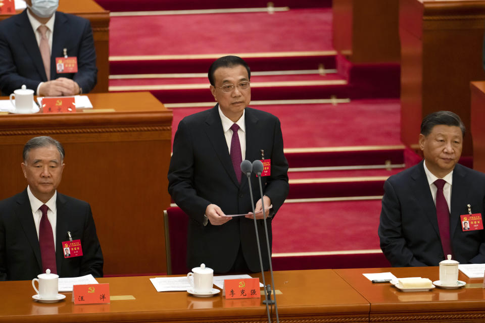 Chinese Premier Li Keqiang is flanked by Politburo Standing Committee member Wang Yang, left, and President Xi Jinping as he speaks during the opening ceremony of the 20th National Congress of China's ruling Communist Party at the Great Hall of the People in Beijing, China, Sunday, Oct. 16, 2022. While Xi is primed to receive a third five-year term as head of China's ruling Communist Party at this week's congress, new members of the party's leading bodies are expected to be appointed at the meeting, whose proceedings are mainly held behind closed doors. (AP Photo/Mark Schiefelbein)