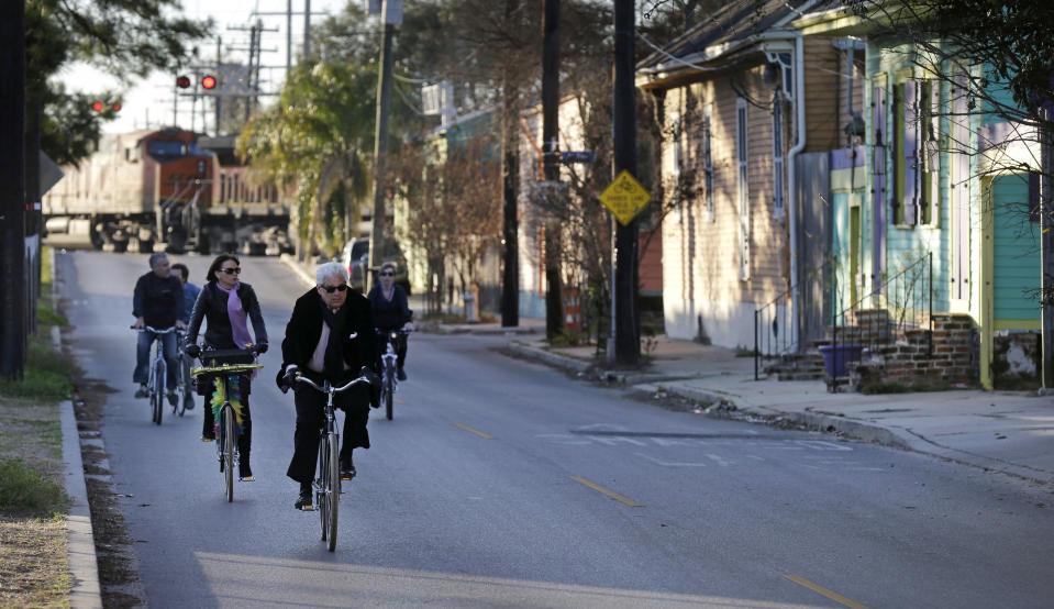 FILE - In this Feb. 13, 2015 file photo, cyclists ride along Chartres St. near the Mississippi River waterfront in the Bywater section of New Orleans. A New Orleans City Council member has released a long-awaited proposal that would ban short-term rentals of whole houses in the city's residential areas. Thursday's move by Kristen Gisleson Palmer drew an immediate rebuke from a spokesman from HomeAway, one of the businesses that arranges short-term vacation rentals online. (AP Photo/Gerald Herbert, File)