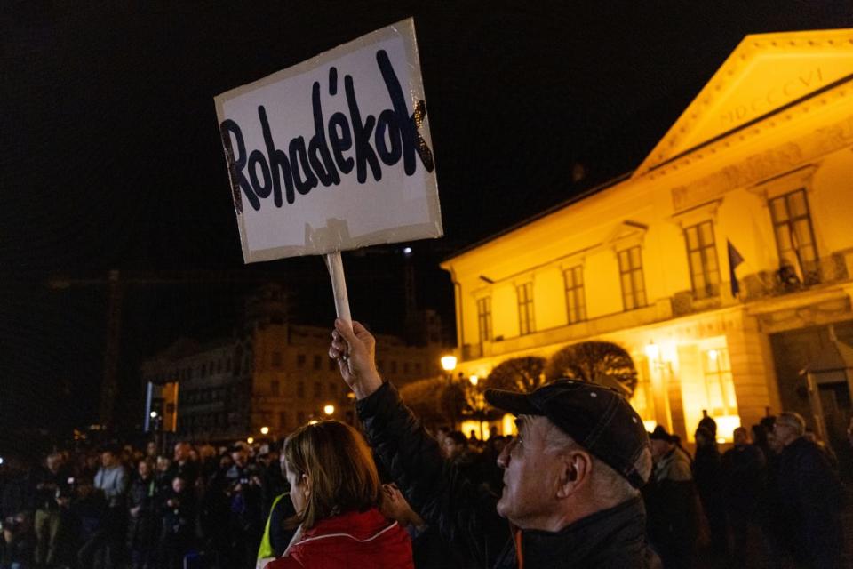 A photo of a protester in Budapest sign a banner reading “Bastards” outside the offices of Hungarian President Katalin Novák.