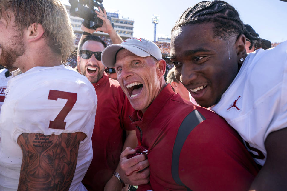 CORRECTS ID TO TIGHT END JOSH FANUIEL, NOT DEFENSIVE LINEMAN RONDELL BOTHROYD - Oklahoma head coach Brent Venables gets a hug from tight end Josh Fanuiel after defeating Texas 34-30 in an NCAA college football game at the Cotton Bowl, Saturday, Oct. 7, 2023, in Dallas. (AP Photo/Jeffrey McWhorter)