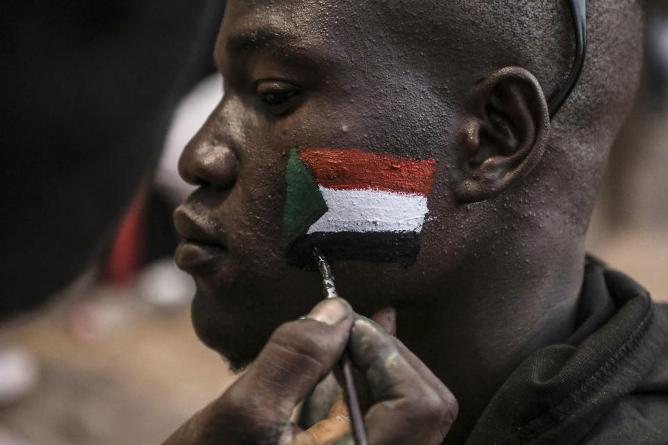 A man's face is painted as Sudanese protesters chant slogans during a rally outside the army headquarters in Sudan's capital Khartoum on Saturday, April 20, 2019. Sudan's military ousted President Omar al-Bashir following four months of street protests against his rule, then appointed a military council it says will rule for no more than two years while elections are organized. Protesters fear the army, dominated by al-Bashir appointees, will cling to power or select one of its own to succeed him.(AP Photo)