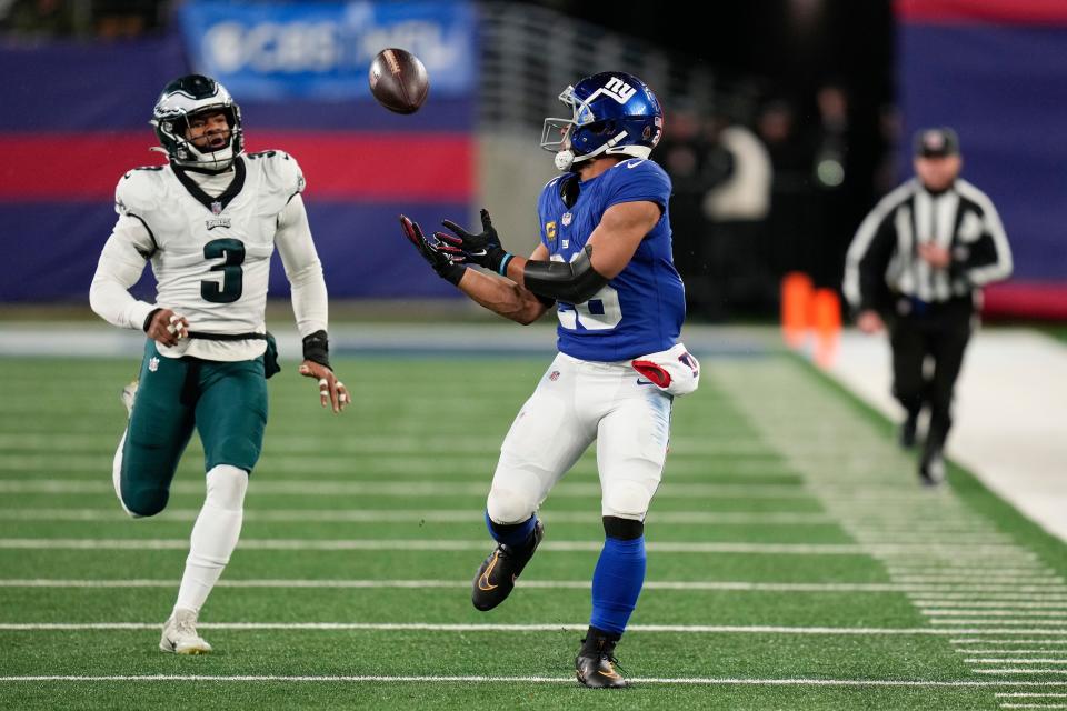 New York Giants running back Saquon Barkley (26) makes a catch against Philadelphia Eagles linebacker Nolan Smith (3) during the second quarter of an NFL football game, Sunday, Jan. 7, 2024, in East Rutherford, N.J.