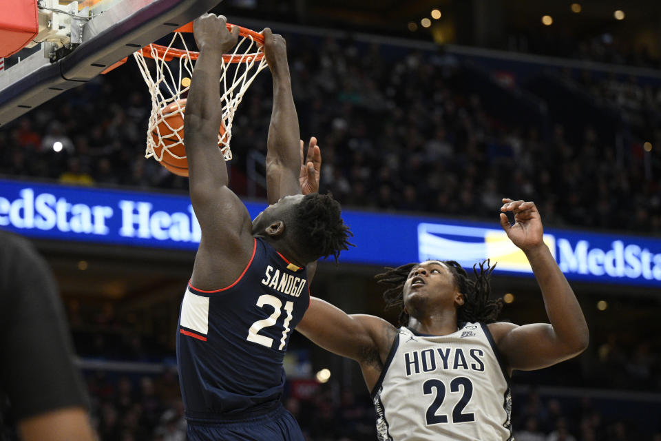 Connecticut forward Adama Sanogo (21) dunks past Georgetown forward Bradley Ezewiro (22) during the first half of an NCAA college basketball game, Saturday, Feb. 4, 2023, in Washington. (AP Photo/Nick Wass)