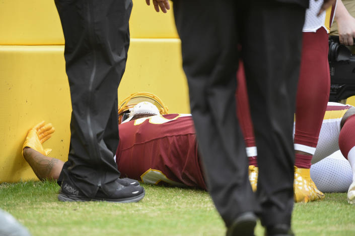 Washington Football Team tight end Ricky Seals-Jones (83) lying on the sidelines after a collision with a cameraman during the first half of an NFL football game against the Philadelphia Eagles, Sunday, Jan. 2, 2022, in Landover, Md. (AP Photo/Mark Tenally)