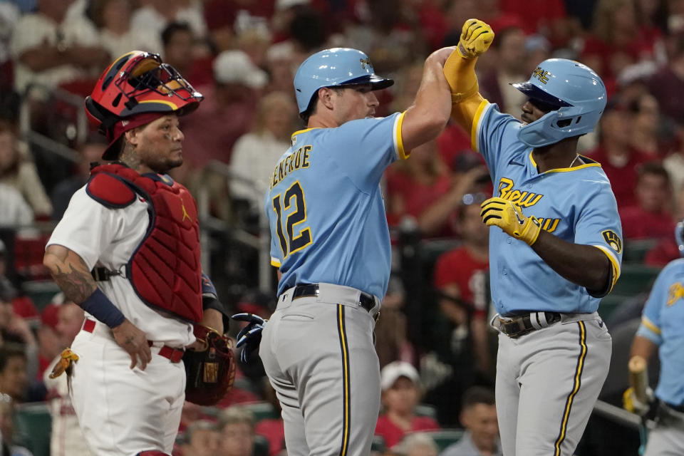 Milwaukee Brewers' Andrew McCutchen, right, is congratulated by teammate Hunter Renfroe (12) after hitting a two-run home run as St. Louis Cardinals catcher Yadier Molina stands by during the fifth inning of a baseball game Tuesday, Sept. 13, 2022, in St. Louis. (AP Photo/Jeff Roberson)