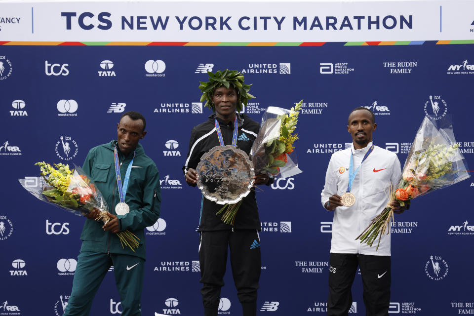 El podio del maratón de Nueva York, con el segundo Shura Kitata (izquierda), el ganador Evans Chebet (centro) y el tercero Abdi Nageeye (derecha), el domingo 6 de noviembre de 2022. (AP Foto/Jason DeCrow)