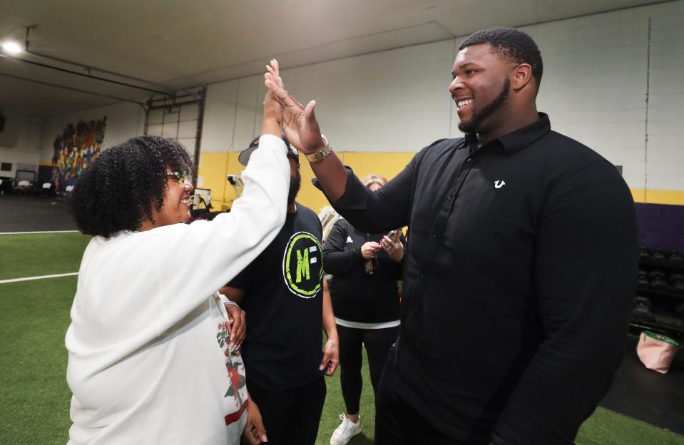 Five-star offensive tackle Kiyaunta Goodwin, right, got a high-five from friend Kamla Jones after Goodwin made the decision to play football at Kentucky instead of Michigan State during  a signing ceremony at the Aspirations gym in Louisville, Ky. on Dec. 15, 2021.  Jones is a UK graduate.