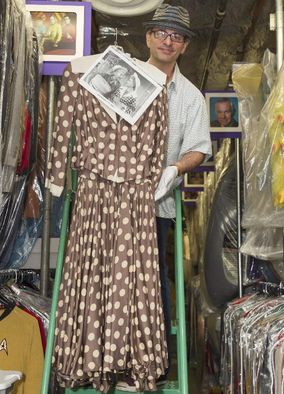 In this Friday, Nov. 30, 2012 photo, James Comisar shows a dress worn by Lucille Ball. The item is part of his television memorabilia collection in a temperature- and humidity-controlled warehouse in Los Angeles. (AP Photo/Damian Dovarganes)