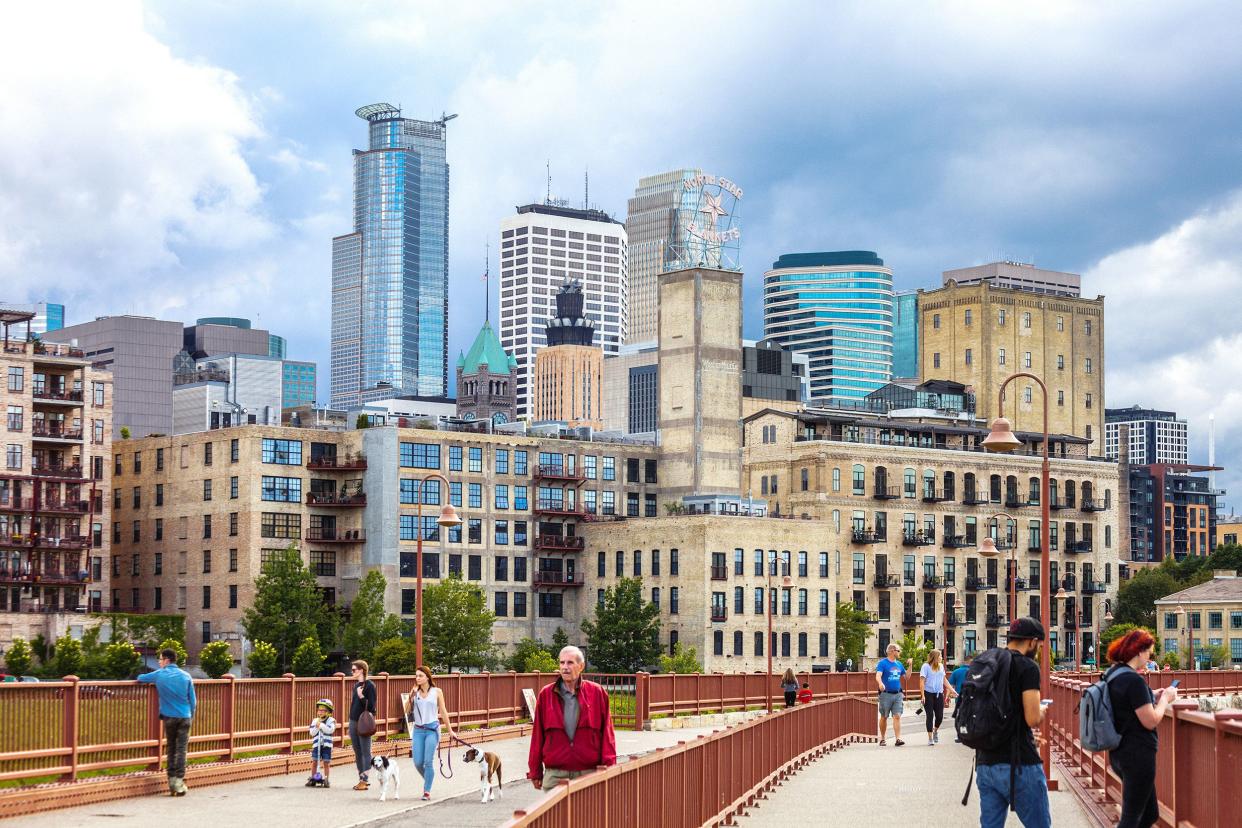 people walking on Stone Arch Bridge to cross Mississippi river