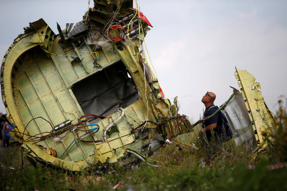 A Malaysian air crash investigator inspects the crash site of Malaysia Airlines Flight MH17, near the village of Hrabove (Grabovo) in Donetsk region, Ukraine, July 22, 2014.  REUTERS/Maxim Zmeyev/File Photo     TPX IMAGES OF THE DAY     