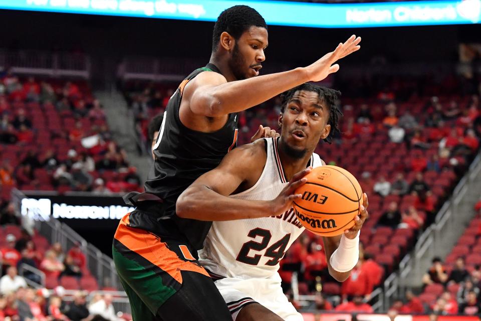 Louisville forward Jae'Lyn Withers (24) attempts to get past Miami forward A.J. Casey (0) during the second half of an NCAA college basketball game in Louisville, Ky., Sunday, Dec. 4, 2022. Miami won 80-53. (AP Photo/Timothy D. Easley)