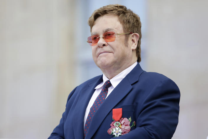 Sir Elton John listens in courtyard of the presidential Elysee Palace in Paris, Friday, June 21, 2019. Sir Elton John received the Legion of Honor, seen on his jacket, France's highest award, during a visit to the presidential Elysee Palace (AP Photo/Lewis Joly, Pool)