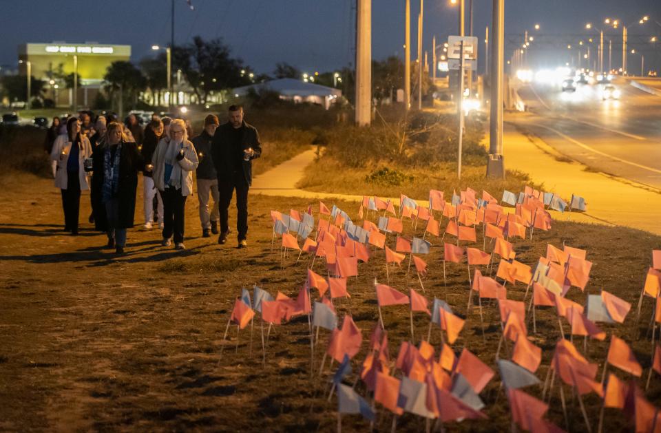 Members of the 14th Judicial Circuit's Human Trafficking Task Force held a vigil at the Hathaway Bridge on Tuesday. The candlelight vigil was in honor of National Human Trafficking Awareness Day. The 282 flags represent the number of child victims in Northwest Florida.