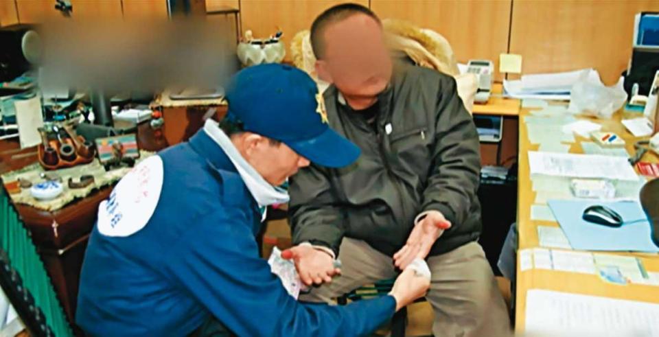 鑑識人員在林文仁（右）手掌滴試劑，證實他沾染死者血跡。（東森新聞提供）