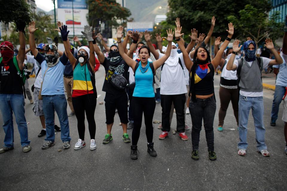 Varios manifestantes corean lemas a la Guardia Nacional durante enfrentamientos en Caracas, Venezuela, el domingo 2 de marzo de 2014. (Foto AP/Rodrigo Abd)