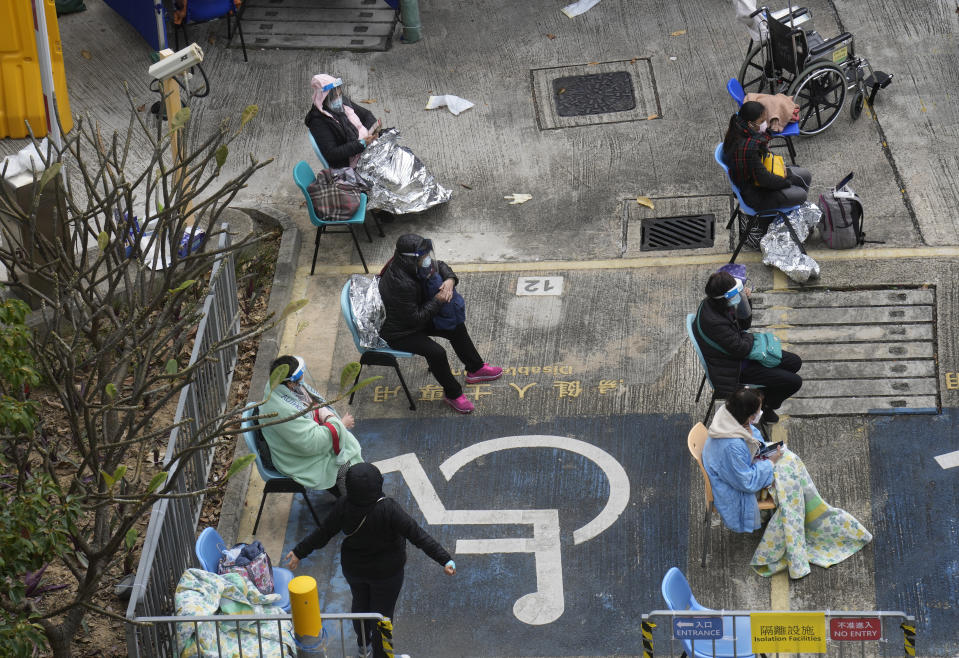 People, including current hospital patients, showing COVID-19 symptoms wait at a temporary holding area outside Caritas Medical Centre in Hong Kong Wednesday, Feb. 16, 2022. China's leader Xi Jinping took a personal interest in Hong Kong's outbreak, saying it was the local government's "overriding task" to control the situation, a Hong Kong newspaper said on Wednesday. (AP Photo Vincent Yu)